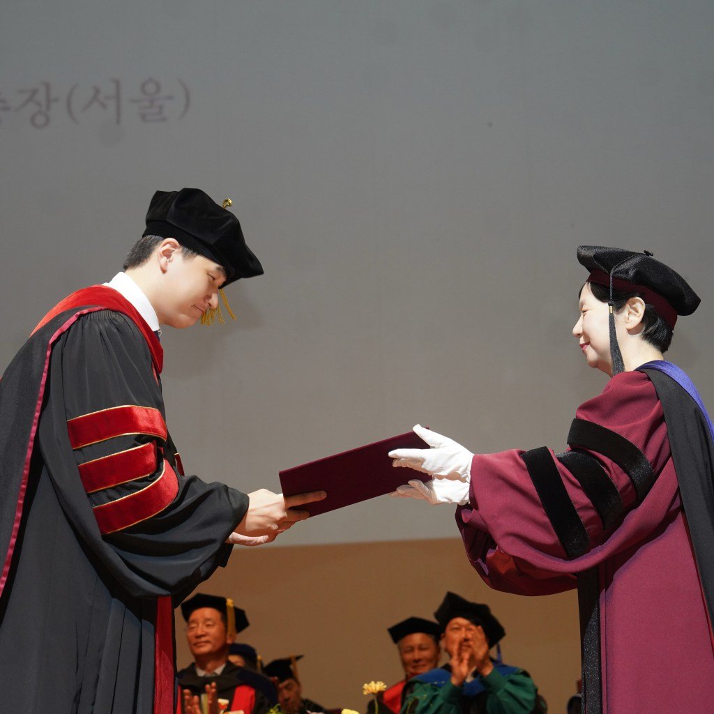 Receiving the doctoral diploma on stage