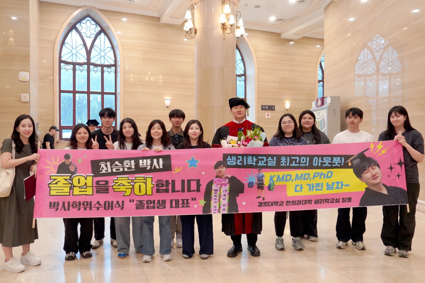 Lab members with a congratulatory graduation banner